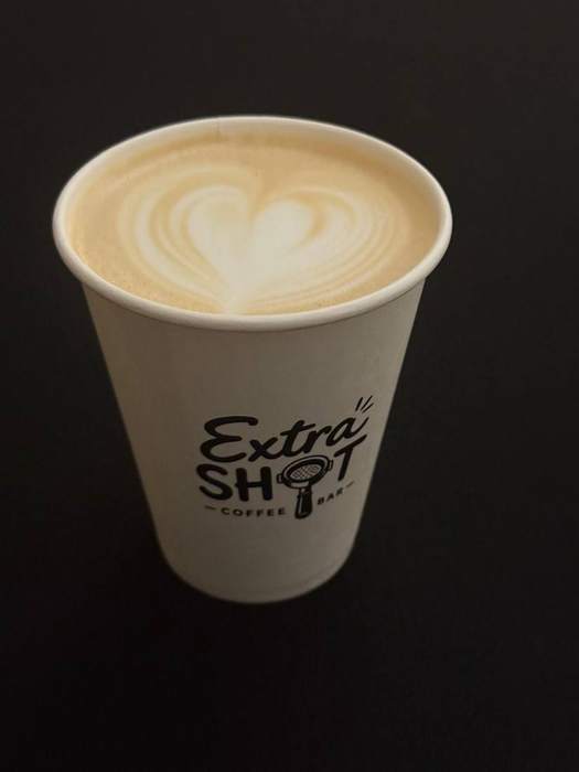 Cană de cafea cu latte art în formă de inimă