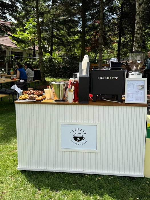 Bar de cafea montat în parc, cu produse de patiserie așezate pe blat